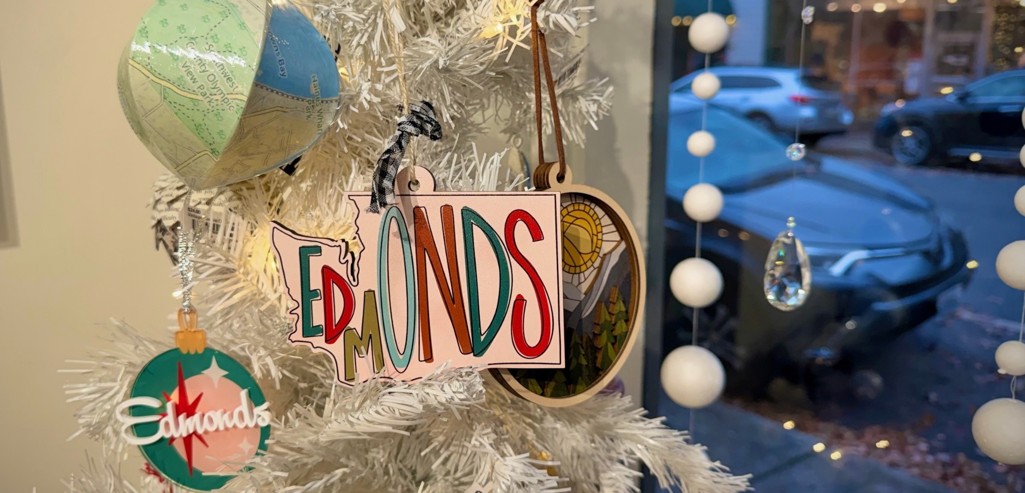 Edmonds ornaments on a white Christmas tree display at crow
