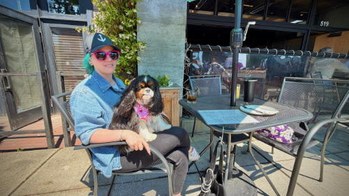 A woman with a dog on her lap on the patio at Leftcraft in Edmonds